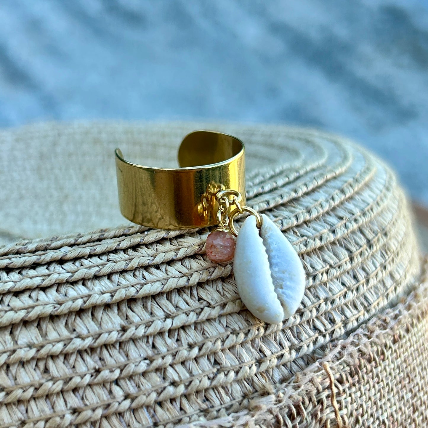 Gold ring with a shell and strawberry quartz charms