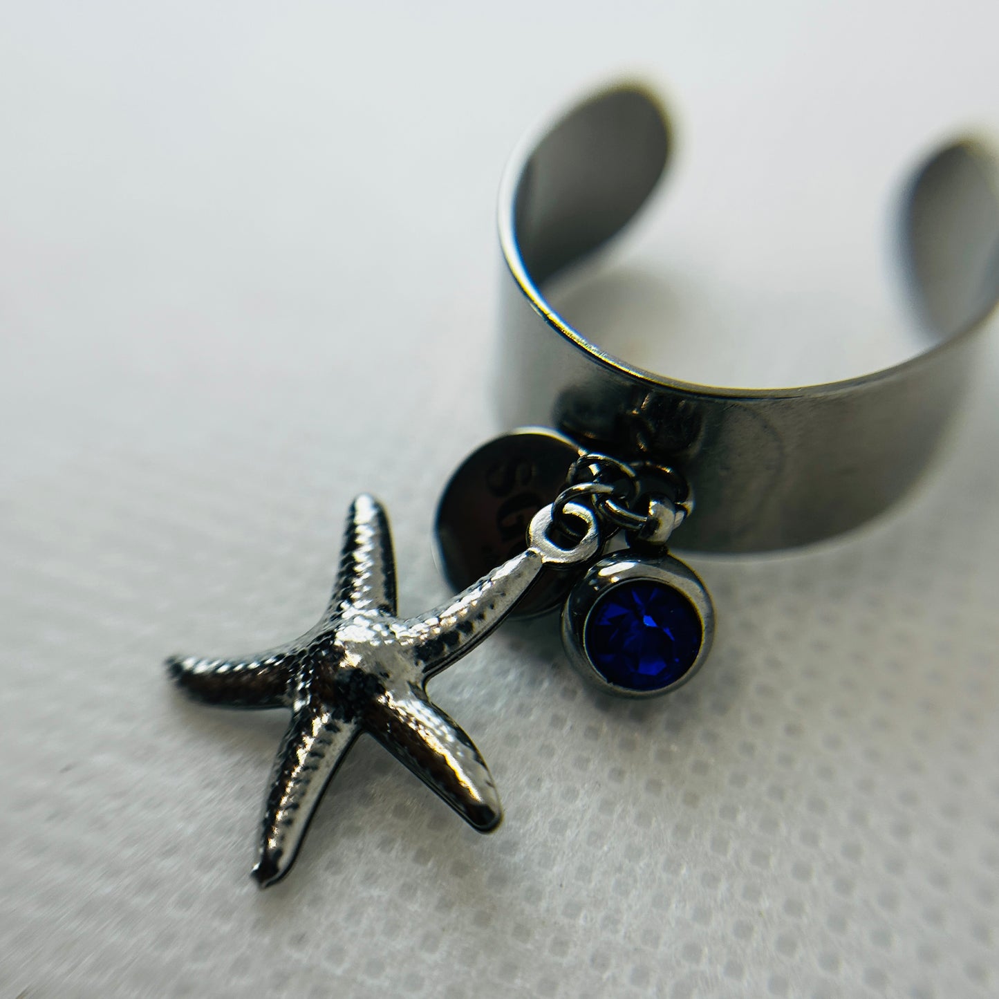 Silver ring with starfish and blue gemstone charm